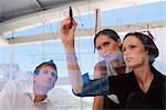 Businesswoman drawing graphs on glass