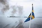 Close-up of Swedish flag with sea in background