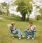 Couple sitting on outdoor chairs in park