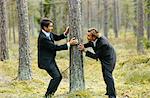 Two businessmen messing about in forest