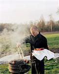 Man removing sausages from barbecue grill