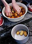 Gros plan des mains de l'homme, laver les pommes de terre dans un bol
