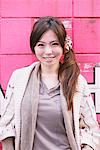 Japanese Women Standing In Front Of Pink Wall