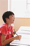 Japanese Boy Writing In Notebook