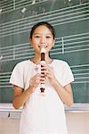 Japanese Girl Playing Flute In Front Chalkboard