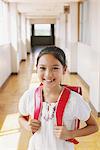 Jeune fille écolière souriante avec sac d'école