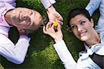 Un homme et une femme d'affaires reposant sur l'herbe, Stockholm, Suède.