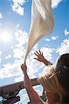 Femme tenant une écharpe en streaming dans le vent, Suède.