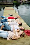 Friends lying on a jetty, Stockholm archipelago, Sweden.