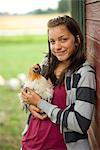 A girl holding a hen, Sweden.