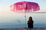 A teenage girl sitting  under a sunshade, Oland, Sweden.