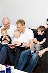 Fathers reading a book to their children, Sweden.