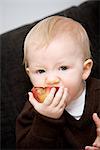 Ein Baby hält einen Apfel, Schweden.