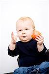 A baby boy holding an apple, Sweden.
