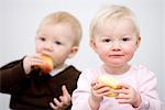 Zwei Babys halten Äpfel, Schweden.