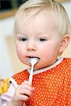 Blond baby girl eating, Sweden.