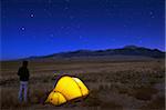 Wanderer und Zelt beleuchtet unter dem Nachthimmel, Great Sand Dunes National Park, Colorado, Vereinigte Staaten von Amerika, Nordamerika