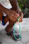 Haitian woman praying with prayer beads, Port au Prince, Haiti, West Indies, Central America