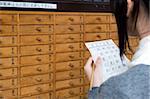 Eine Mädchen liest ihr Omikuji (Papier Oracle) mit Sensoji-Tempel in Asakusa, Tokio, Japan, Asien