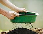 Hands sifting soil outdoors