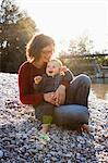 Mother holding baby by creek