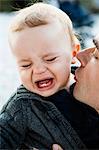 Father kissing crying baby