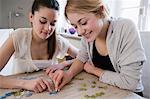 Teenage girls working on jigsaw puzzle