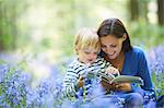 Mother and son reading in forest