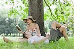 Couple relaxing under tree together