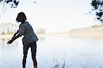 Girl skipping stones in lake