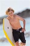 Planche de surf comptable garçon sur la plage