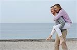 Man carrying girlfriend on beach