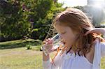 Girl drinking glass of water in backyard