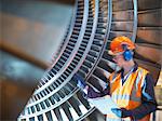 Travailleur inspecte la turbine dans une centrale électrique