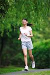 Woman Listening Music while Jogging In Park