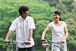 Couple Walking Together In Park With Bicycles