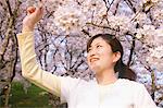 Teenage Girl Touching Blooming Cherry Tree