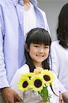 Small Girl Holding Bunch Of Yellow Flowers