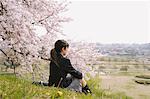 Lycéenne, assis sous l'arbre de la cerise fleur
