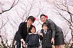 Group Portrait Of Japanese Family Under Blooming Trees