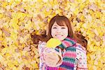 Japanese Women Lying On Ginkgo Leaves And Holding Leaf