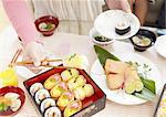 Woman's hands picking up sushi