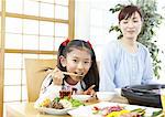 Mother and daughter eating Japanese barbeque