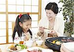Grandmother and granddaughter eating Japanese barbeque