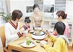 Parents et enfants assis autour yosenabe