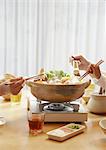 Family's hands eating Japanese hot pot