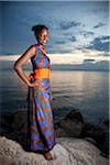 A Burundian girl models clothes at sunsest on the shore of lake Tanganyika.