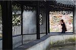 Homme en passant devant la porte d'entrée dans le jardin de l'Humble Administrateur (patrimoine mondial UNESCO), Suzhou, Jiangsu, Chine