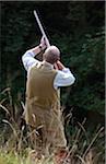 TKO Wiltshire. Ein Mann feuert seine Schrotflinte auf einem angetriebenen Rebhuhn schießen.