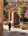 A tourist walks down the street in Calvi on the island of Corsica